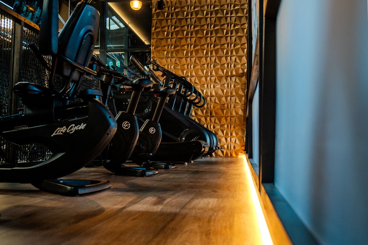 Life Fitness Ergometer mit LED-Ambientebeleuchtung und Holzboden im Cardiobereich des GymOne 24/7 Bitburg